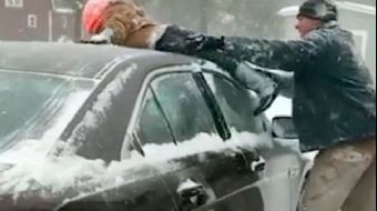 Bir baba, arabasının üzerindeki karları temizlemek için çocuğunu kullandı